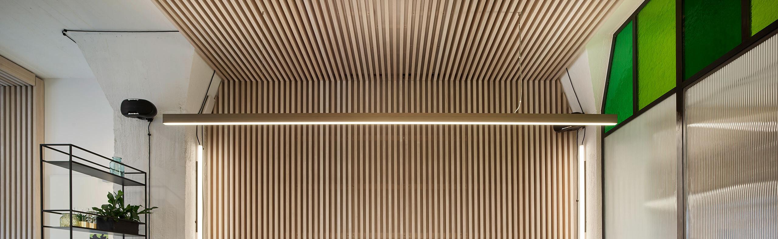 Moderne Bürobeleuchtung mit blendfreien LED-Pendelleuchten über den Schreibtischen.