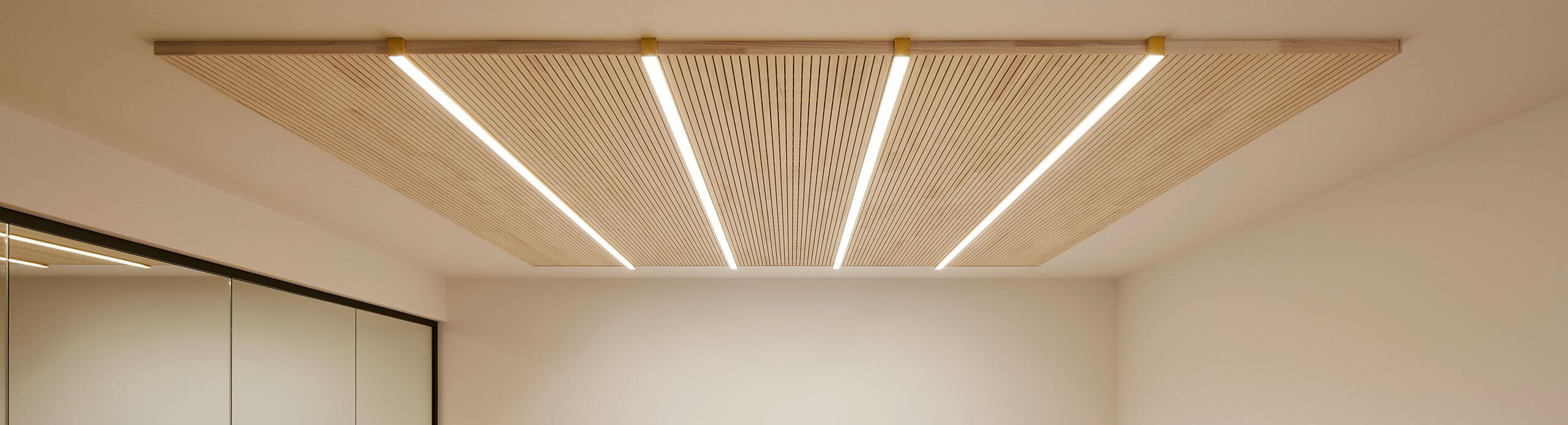 Moderne Akustikleuchten über Arbeitsplätzen zur Verbesserung der Raumakustik im Büro.